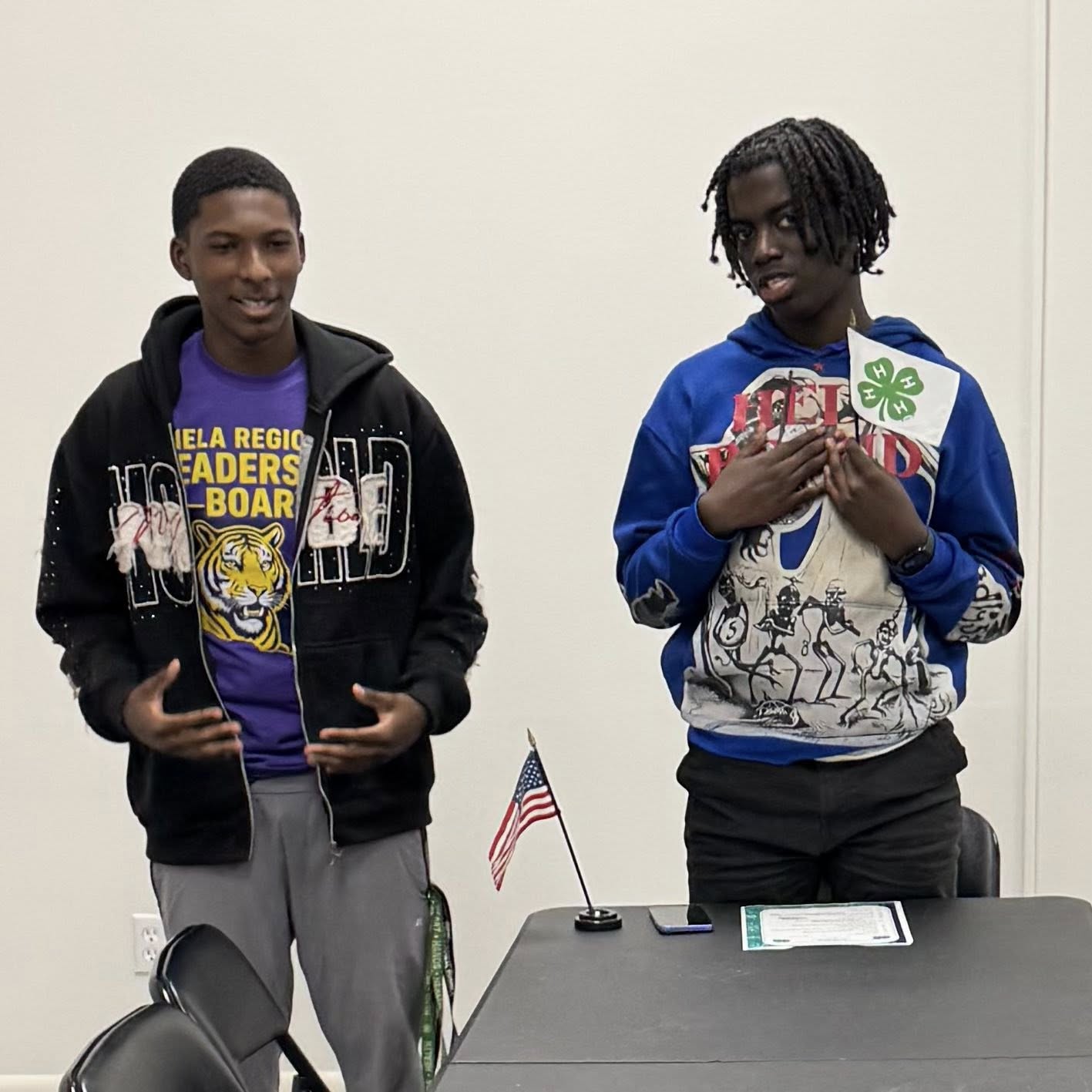 Two boys standing at the end of a table.